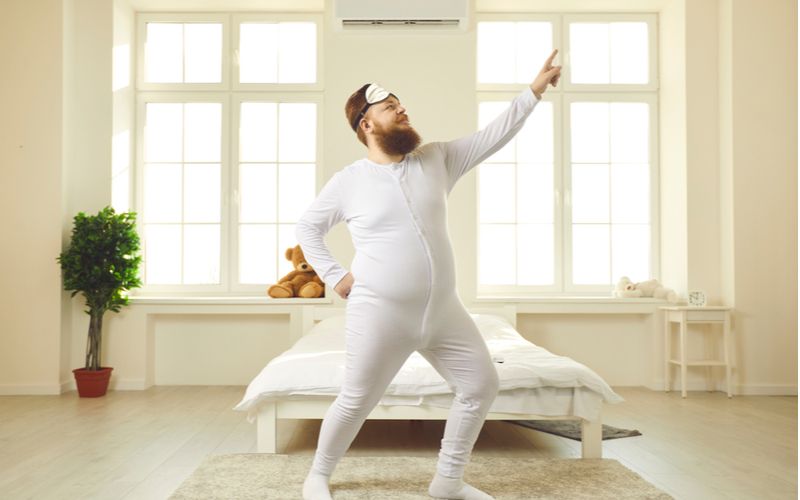 Cviky na predčasnú ejakuláciu - muž v bielej pyžame cvičí pred posteľou