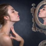 Choking - praktika BDSM, žena pred zrkadlom má prsty na svojom krku